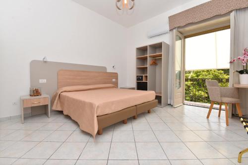 a bedroom with a bed and a large window at Hotel Gentile in Agerola