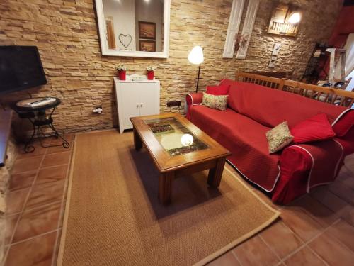 Sala de estar con sofá rojo y mesa de centro en Casita Pirón, en Adrada de Pirón