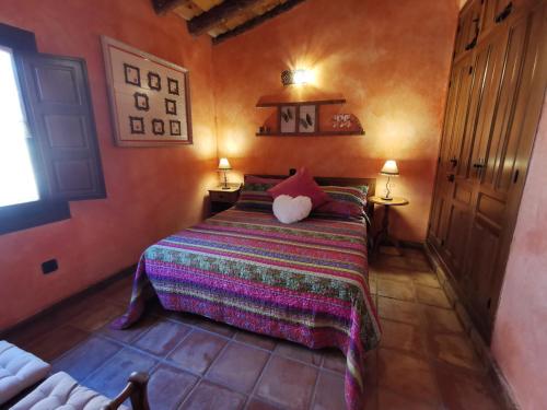 1 dormitorio con 1 cama en una habitación con 2 lámparas en Casita Pirón, en Adrada de Pirón