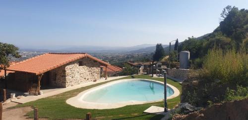 a large swimming pool in a yard with a house at Casa Rosmaninho - Izei in Chaves