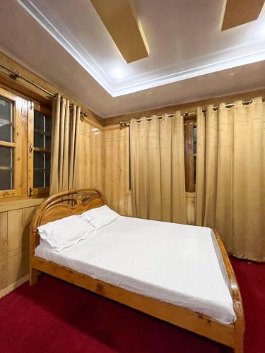 a bed in a room with curtains in a room at Paradiso Lodge Skardu in Skardu