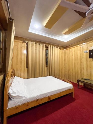 a bed in a room with wooden walls at Paradiso Lodge Skardu in Skardu