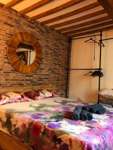 ピサにあるCasa Torre San Lorenzoのレンガの壁の客室で、大型ベッド1台を利用できます。