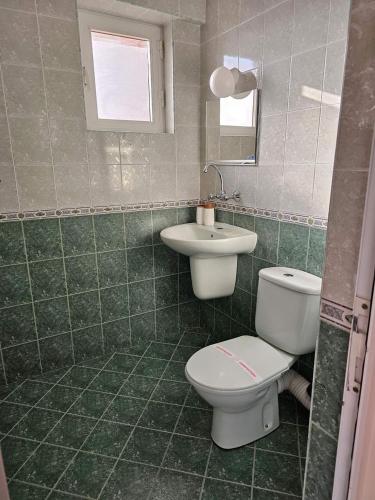 a bathroom with a toilet and a sink at Lotos Apartments in Kiten