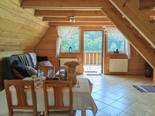 a living room with a table and chairs in a attic at Agroturystyka "U Macieja" in Teleśnica Oszwarowa