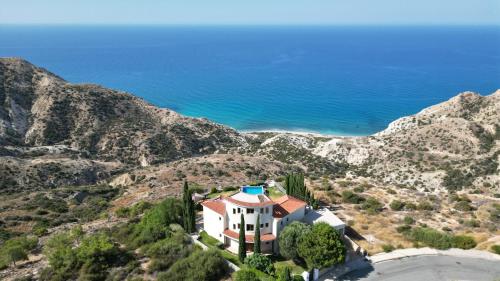 a house on a hill with the ocean in the background at Matteo Villa Limassol Cyprus in Limassol