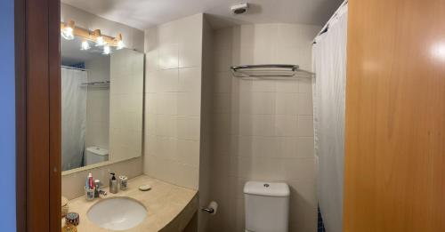 a bathroom with a sink and a toilet and a mirror at Blue Ocean in Platja d'Aro