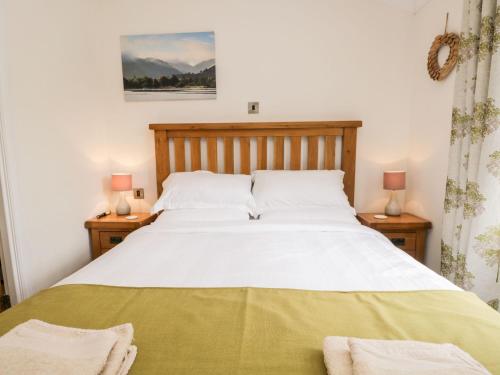 格蘭奇奧沃桑茨的住宿－Pippin Lodge，一间卧室配有一张带两盏灯的大型白色床。