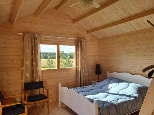 a bed in a wooden room with a window at Jootme-Andruse Puhkemaja in Kuressaare