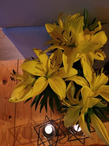 a bouquet of yellow flowers in a vase on a table at Apartament LILLA in Jelenia Góra