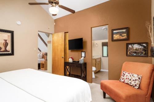 a bedroom with a bed and a chair and a television at Prescott Pines Inn in Prescott