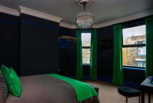 a bedroom with blue and green curtains and a bed at The Bedford Inn in Ramsgate