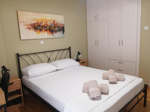 a bedroom with a white bed with towels on it at Central Home in Kalamata