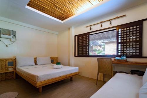 a bedroom with a bed and a desk and a window at Tam Coc Green Fields Homestay in Ninh Binh