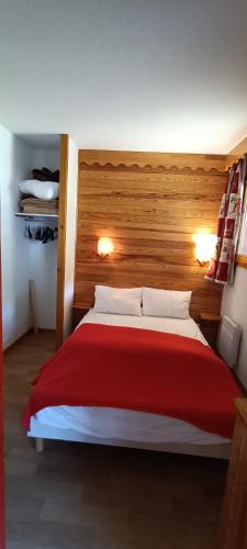 - une chambre avec un lit rouge et blanc et 2 lampes dans l'établissement Appartement coeur de station village Saint Francois Longchamp, à Saint-François-Longchamp