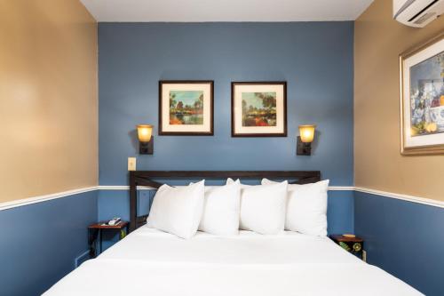 a bedroom with blue walls and a bed with white pillows at Prescott Pines Inn in Prescott