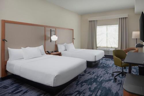 a hotel room with two beds and a desk at Fairfield by Marriott Inn & Suites Middletown in Middletown