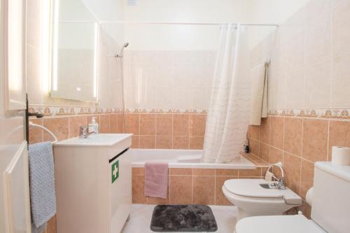 La salle de bains est pourvue de toilettes, d'un lavabo et d'une baignoire. dans l'établissement Sunset Vau, à Portimão
