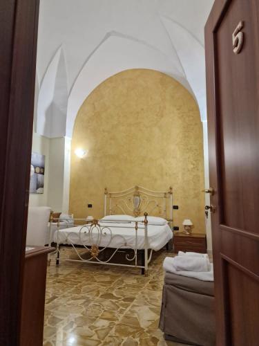 una camera con due letti in una stanza con un arco di Lu Zezzu a Sannicola