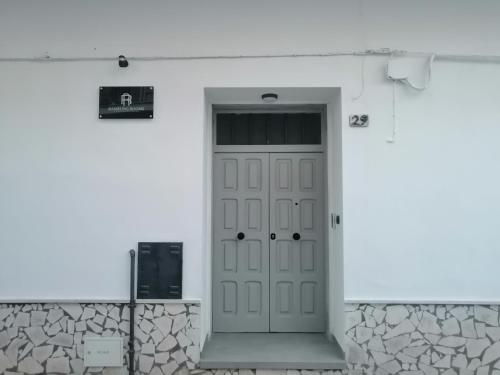 Una puerta en un edificio blanco con un cartel. en Rambling Rooms, en Campomarino