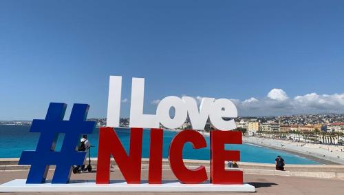 un panneau sur lequel on peut lire « Love Nife » devant une plage dans l'établissement Appart Nice Centre - Terrasse privé Exceptionnelle - Supérieur 3 pièces AC - Garage privé, à Nice
