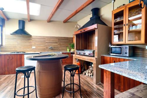a kitchen with a bar with stools in it at Cueva con jacuzzi a 20 minutos de Valencia in Benaguacil