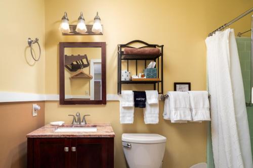 a bathroom with a toilet and a sink and a mirror at Prescott Pines Inn in Prescott