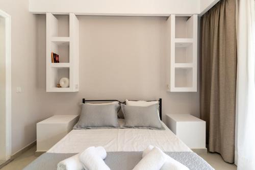 a bedroom with a bed with white walls and shelves at SkyBlue Horizon Studio 2 in Tsilivi