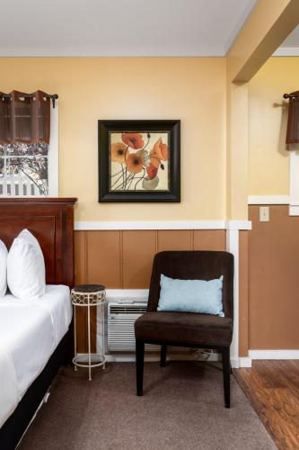 a hotel room with a bed and a chair at Prescott Pines Inn in Prescott