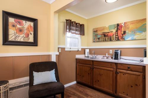 a bathroom with a sink and a chair at Prescott Pines Inn in Prescott