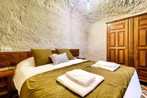 a bedroom with a bed with towels on it at Cueva con jacuzzi a 20 minutos de Valencia in Benaguacil