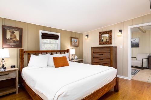 a bedroom with a large white bed and a living room at Prescott Pines Inn in Prescott