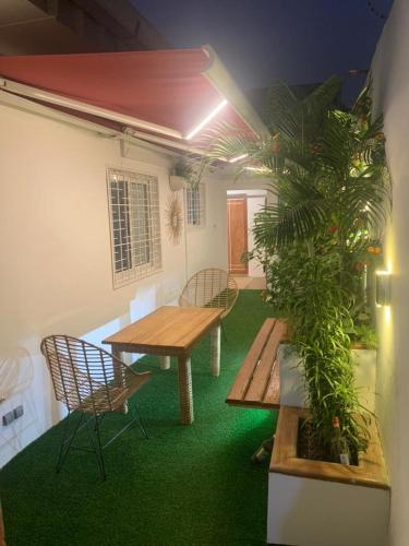 a patio with a table and chairs and a plant at Comme chez soi 2 in Tchimbanmba