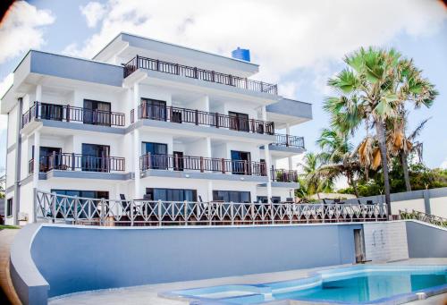 um edifício branco com uma piscina em frente em Majula Boutique Hotel em Sere Kunda