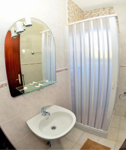 a bathroom with a sink and a shower with a mirror at Menina do Rio in Rio Caldo