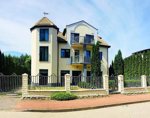 a large house with a fence in front of it at Willa Karolinka in Łeba