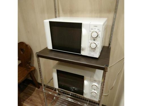 a microwave sitting on a shelf with a microwave oven at QUEEN'S HOTEL CHITOSE - Vacation STAY 67720v in Chitose
