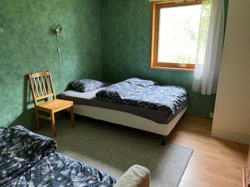 a bedroom with two beds and a chair and a window at House in Røros in Røros