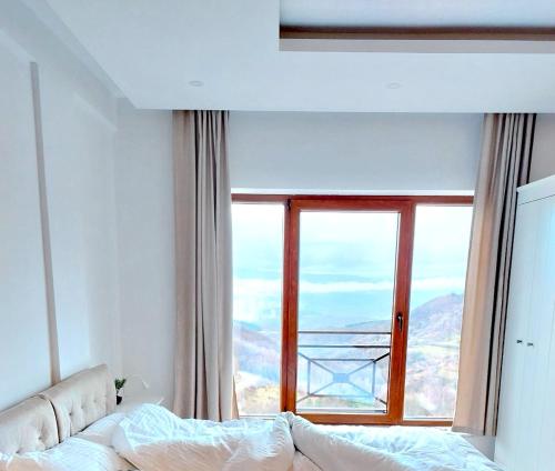 een slaapkamer met een bed en een groot raam bij Apartman Laura Milmari Resort in Kopaonik