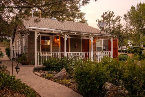 a small house with a white fence and a porch at Prescott Pines Inn in Prescott