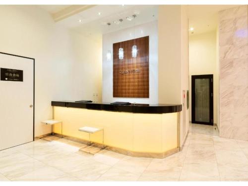 a lobby with a counter with two benches in a room at QUEEN'S HOTEL CHITOSE - Vacation STAY 67737v in Chitose