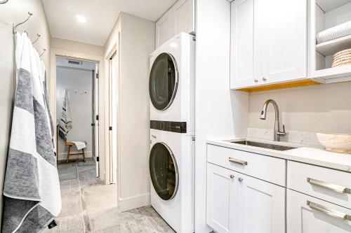 a white laundry room with a washer and dryer at Dune House in Manistee