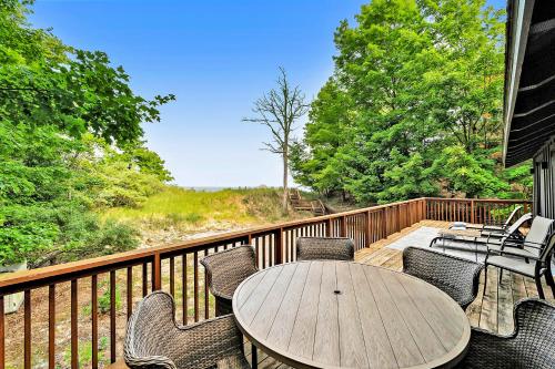 a wooden deck with a table and chairs at Dune House in Manistee