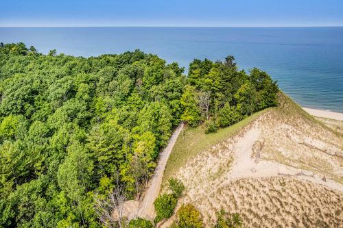 an aerial view of a hill with trees and the ocean at Dune House in Manistee