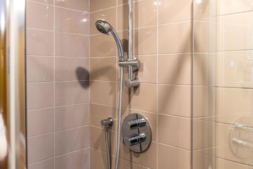 a shower with a shower head in a bathroom at Trendy Kings Cross Flat in London