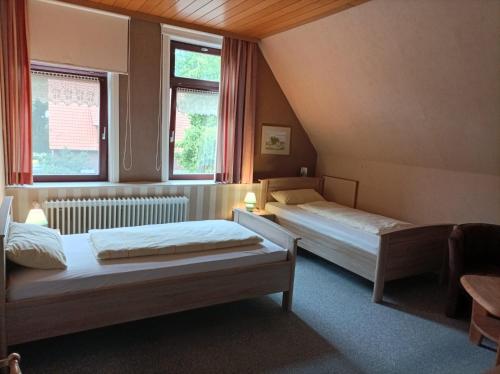 two beds in a room with two windows at BmB Kirchwalsede Monteurzimmer / Unterkunft in Kirchwalsede