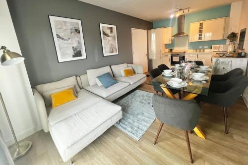 a living room with a white couch and a table at Modern, comfy 2 bedroom flat in Hatfield town centre in Hatfield
