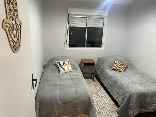 En eller flere senge i et værelse på Confortável Apartamento em Bagé