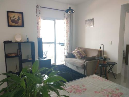 a living room with a couch and a table at Aconchegante Apto Praia do Centro in Itanhaém