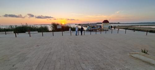 a group of people standing near a food truck on the beach at La Vie En Rose in Marsala